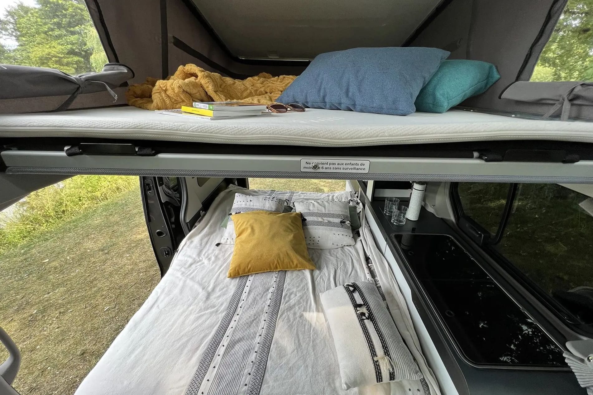Foto campervan 5 zitplaatsen interieur zicht op bed in hefdak